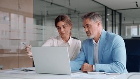 Two successful happy professional business partners executive leaders managers wearing suits working in office looking at computer technology discussing digital strategy together at corporate meeting. - Powered by Shutterstock - Get 15% off with code: PIKWIZARD15