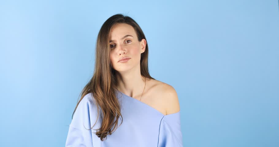 Brunette woman looking camera pointing fingers herself ask me no i do not need it. Girl point on her, waving her hands and say no isolated on blue background. Royalty-Free Stock Footage #3489292405
