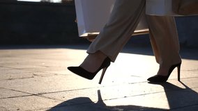 Feet of female customer in high heel shoes walking at sidewalk after purchases with shopping bags . Fashionable woman carries paper packets going along urban street. Concept of leisure and free time - Powered by Shutterstock - Get 15% off with code: PIKWIZARD15