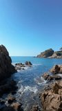 Vertical video, Cala Sant Francesc in Blanes Costa Brava copy Space beach, with rocks sand and vegetation