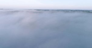 The sky is covered in a thick layer of fog, creating a sense of mystery and calmness, areal video