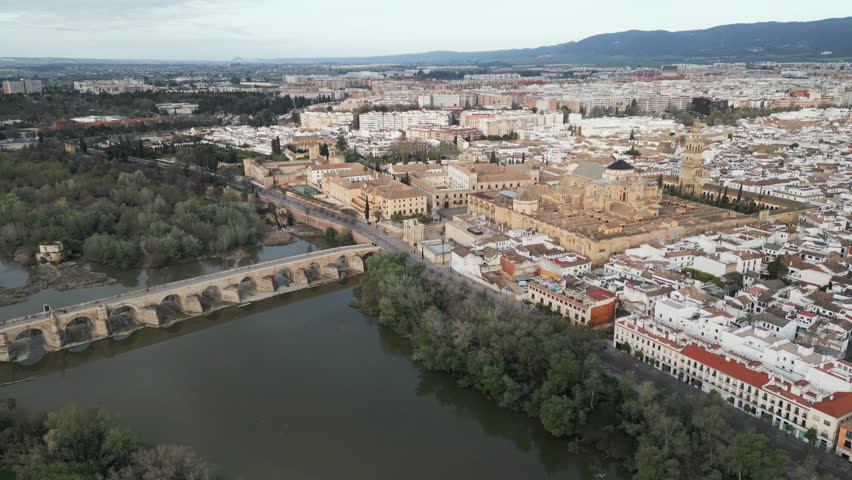 Aerial perspective of the Guadalquivir River running throug the old town Cordoba located in the Andalusia province of Spain. Ascending shot.