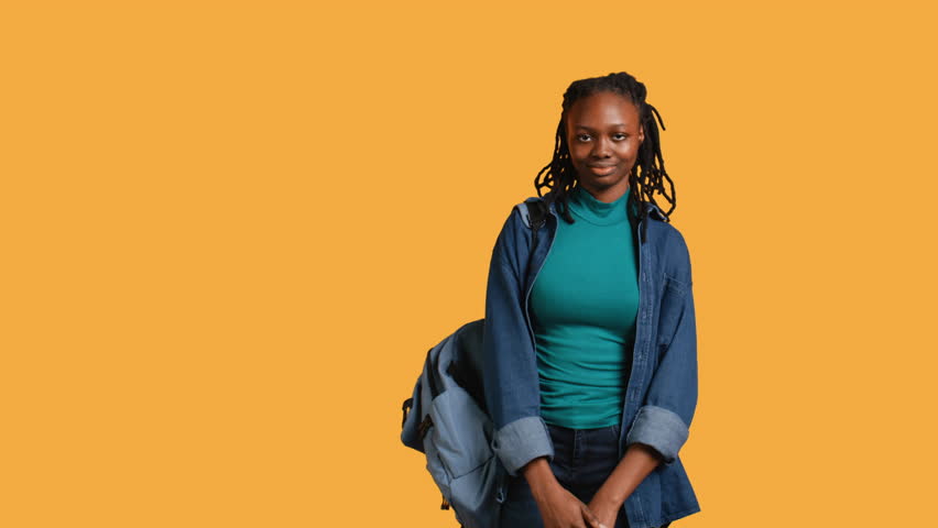 Upbeat african american teenager goofing around, feeling joyous, isolated over studio background. Portrait of happy young girl acting silly, showing positive demeanor, camera B Royalty-Free Stock Footage #3489500679
