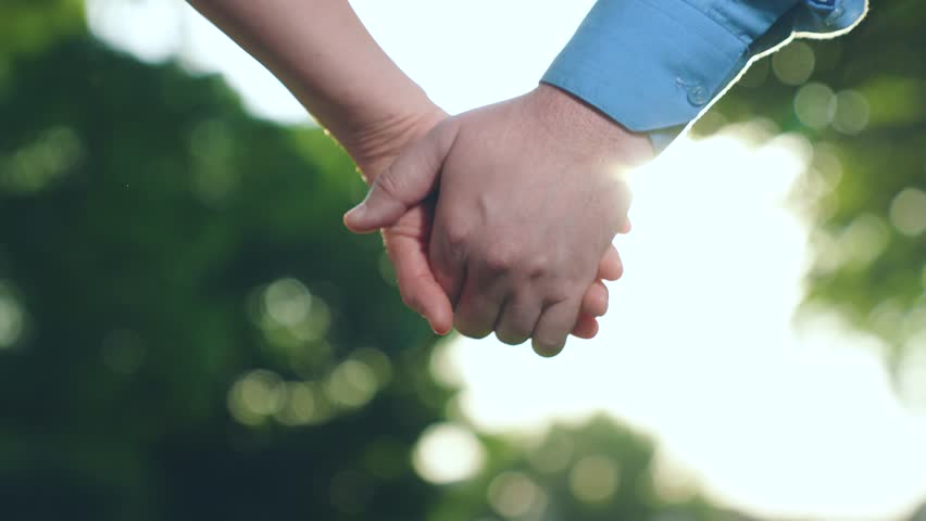 Separation of hands of man of woman. Separation, separation, quarrel. Closeup of guy lets go of girls hand, separation. Pair of man, woman separate their hands in front of sun. Family at sunset Royalty-Free Stock Footage #3489525245