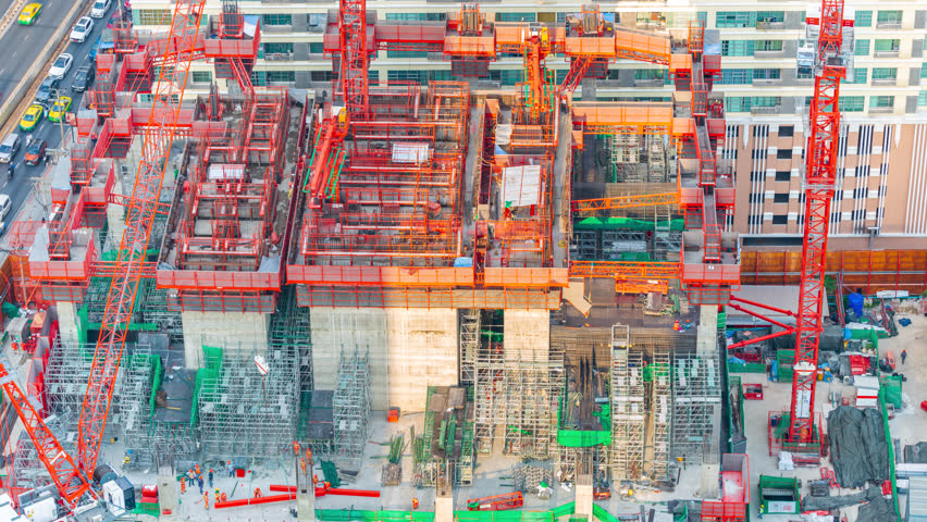 Intricate Construction Site of a Large Building, Aerial view of a large construction site bustling with activity, featuring towering cranes and a maze of scaffolding.