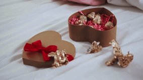Chocolates in heart shaped box. Arranging a variety of chocolate dipped strawberries in a heart shaped gift box on white background. Heart shaped of chocolate. concept of Valentine day 4k video.