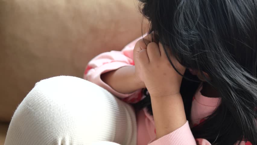 a upset child girl cover her face with hand 