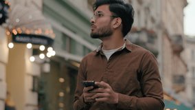 Confused lost Indian Arabian ethnic man student traveler tourist guy businessman male looking around using mobile phone online GPS map application navigation problem route outdoors abroad city street - Powered by Shutterstock - Get 15% off with code: PIKWIZARD15