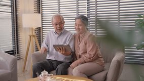 Asian grandparents video call with family. Senior couple talking waving hands to greeting through the digital tablet