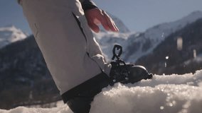Skier puts his foot on the snow, fastens the clasp. Adjusting boat buckle on ski boot, close up. Alpine snowy mountains in sunny weather. Preparation for skiing, essential ski gear - Powered by Shutterstock - Get 15% off with code: PIKWIZARD15