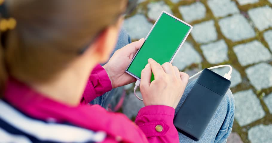 Person Charging Smartphone with Portable Battery