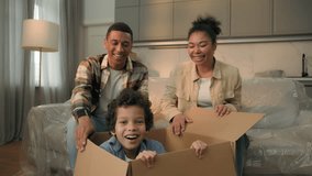 African American family moving in new home relocation happy parents unpacking parcel surprise funny joyful son little boy child jumping out of cardboard box playing game hide and seek kid having fun - Powered by Shutterstock - Get 15% off with code: PIKWIZARD15