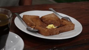 4k video footage of asian man eating Butter toast for breakfast at kopitiam. Concept for restaurant and eatery.