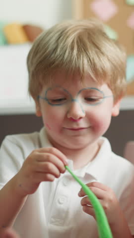 Brother and sister play with fidget toys sitting in playroom slow motion. Schoolgirl waves hands and boy tries to catch bright wiggle toys laughing happily closeup