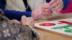 Group of unrecognizable senior woman playing the classic game Ludo or Parchis at nursing home. High quality 4k video