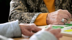 Group of unrecognizable senior woman playing the classic game Ludo or Parchis at nursing home. High quality 4k video