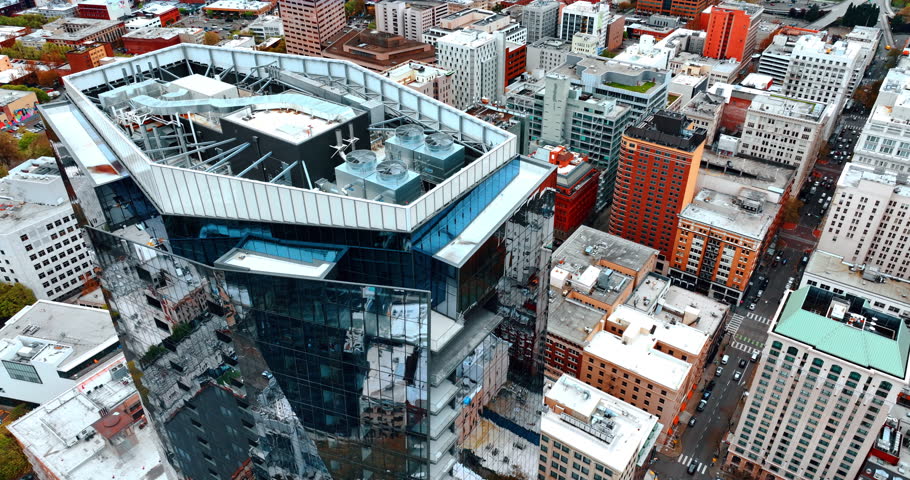 Roof top of the high-rise building with mirror facades. Drone descending over the downtown of Portland, Oregon, the USA.