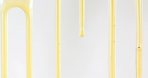 Close up golden sweet honey dripping line on white background , 4K Dci resolution