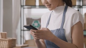 Go green asian SME owner chat online happy talk AI chatbot phone. Young seller asia woman typing mobile work at home office desk easy selling smart CRM platform app for eco shop retail net zero store. - Powered by Shutterstock - Get 15% off with code: PIKWIZARD15