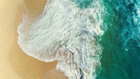 Aerial view waves break on white sand beach. Sea waves on the beautiful beach aerial view drone 4k shot.