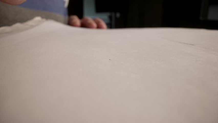 Automatic pen draws a straight line on a white paper background, macro photography. Close-up of a pen drawing a straight line.