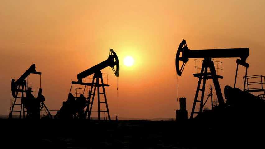 working oil pumps silhouette against timelapse sunset