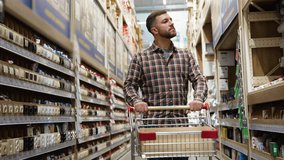A customer with a trolley walking in a construction store in the electrical goods section - Powered by Shutterstock - Get 15% off with code: PIKWIZARD15