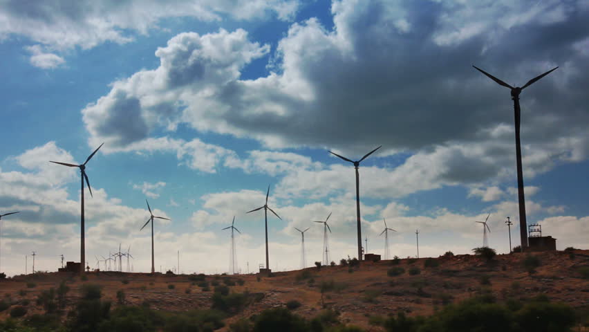 wind farm - turning windmills against timelapse clouds