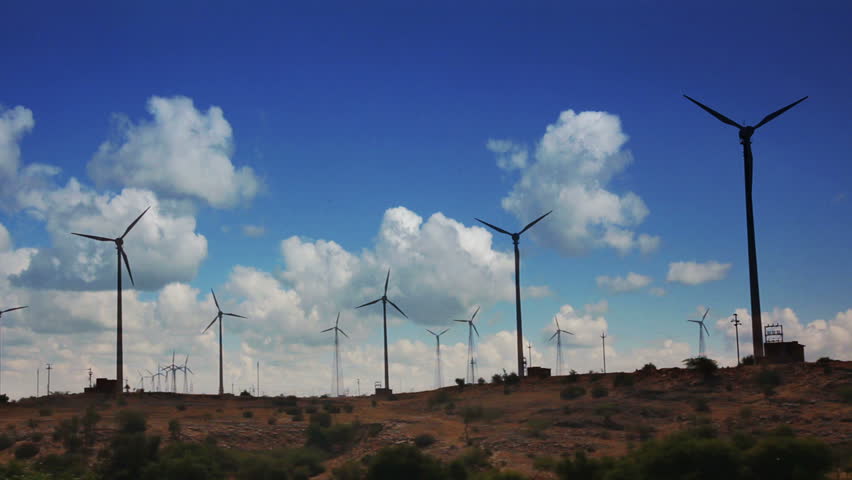 wind farm - turning windmills against timelapse clouds