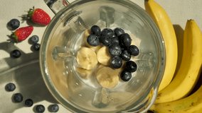 Grind the Top View berry milkshake in a blender and beat with the addition of blueberries and banana pieces. Prepare a berry-fruit smoothie using a blender. Slow motion cooking smoothie - Powered by Shutterstock - Get 15% off with code: PIKWIZARD15