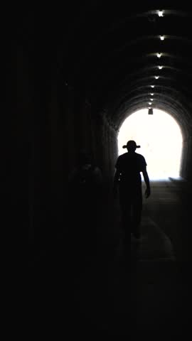 Slow motion, hikers walking in the tunnel