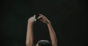 4K video footage beautiful female ballet dancer dancing on black background, slow motion, passes hands