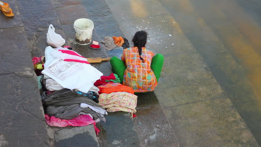 UDAIPUR, INDIA - NOVEMBER 24, 2012: Indian woman washing clothes in the lake in