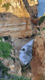 Close up video of waves in Ponta da Piedade in Lagos, Portugal. Famous coastline and rock caves at Atlantic Ocean in Algarve region. Summer touristic destination for vacation.