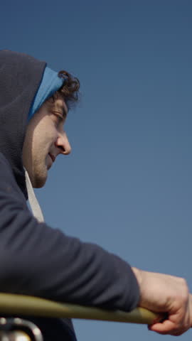 A hooded fisherman trying to catch fish