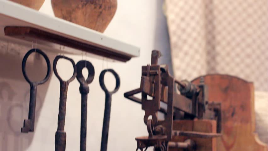 Keys hanged under rack. Panoramic view of old-fashioned pottery workshop. Working area of potter. Working tools view. Three complete clay pots on floor