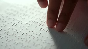 Hand of a blind person reading some braille text on page paper to learn. Finger of blind student touching the braille alphabet Code on sheet. Disabled person concept. - Powered by Shutterstock - Get 15% off with code: PIKWIZARD15
