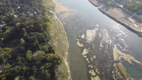 top aerial video shot  view by drone of a river in rural village of India on a bright sunny afternoon