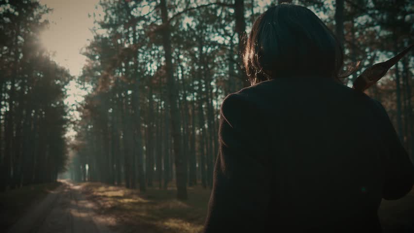 Maniac wearing coat and wig for being unrecognizable walking with axe in forest, danger killer walking in mystery woods to find victim. Maniac Murder and crime, Halloween horror day concept