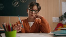 Caucasian thoughtful pensive schoolboy at school looking at textbook reading book education study learning thinking difficult study learn task child boy kid pupil student at table desk think lesson - Powered by Shutterstock - Get 15% off with code: PIKWIZARD15