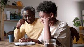 Thoughtful elder explaining schoolwork to his pensive grandson, sharing wisdom at the study table. Grandfather Helping Teenager with Challenging Homework - Powered by Shutterstock - Get 15% off with code: PIKWIZARD15