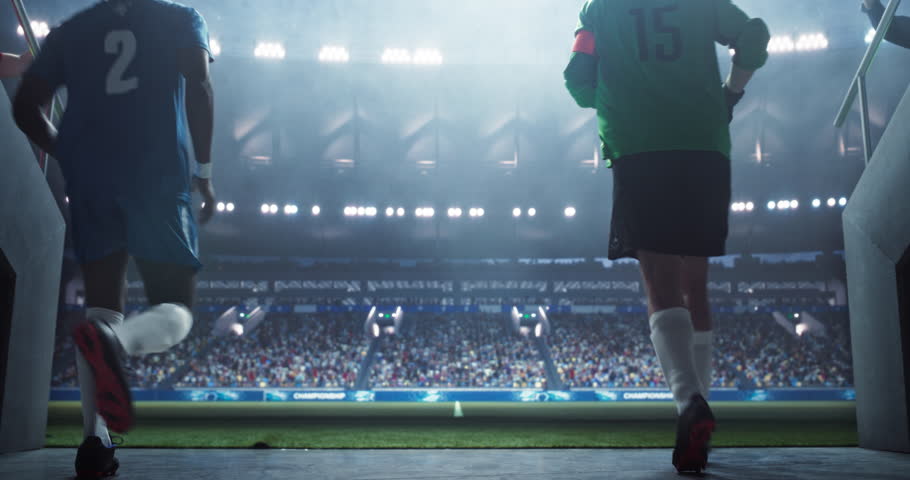 Traditional Soccer Walkout: Portrait of Determined Players Entering the Football Stadium to the Cheers and Support of the Anticipating Loyal Fans. Cinematic Low Angle Back View Footage