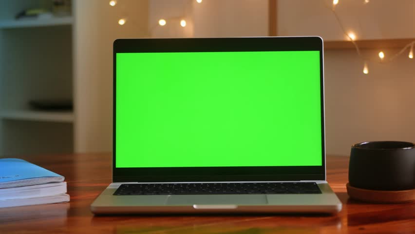 Close up table of distant worker at home. Modern laptop computer with chroma key green screen. Royalty-Free Stock Footage #3491291135