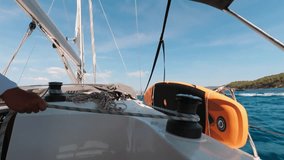 A man on a yacht adjusts the sail control rope after sailing. - Powered by Shutterstock - Get 15% off with code: PIKWIZARD15