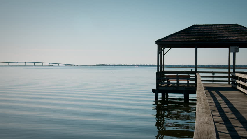 Clear Ripples in Morning Bay Water Under Pier