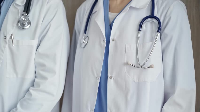 Professional healthcare team in uniform. Two doctors with stethoscopes are standing straight. Medicine concept