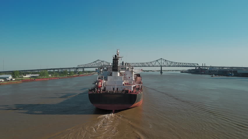 Aerial drone shot of Mississippi River waterfront and bridge in New Orleans, Louisiana