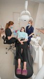 Professional Female Dentist Shows Patient how to Brush Teeth Properly in a Dental Office. Beautiful Woman Doctor. Healthcare and Medicine Concept. Vertical Video