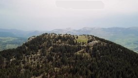 Drone footage captures mountain, forest towering skyward. Aerial view shows mountain, forest in majestic display. Video highlights mountain, forest surrounded by dense greenery
