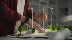 A Caucasian man who is actively involved in research into green energy using models of windmills. His work aims to create sustainable urban environments based on the use of alternative energy sources - Powered by Shutterstock - Get 15% off with code: PIKWIZARD15
